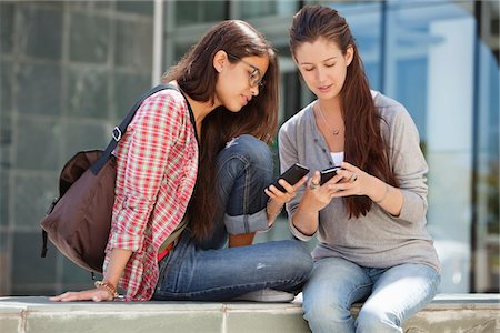Two young female friends reading messages Stock Photo - Premium Royalty-Free, Code: 6108-05869905
