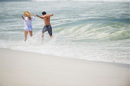 surf couple - Vue arrière de tourner un couple sur la plage Photographie de stock - Premium Libres de Droits, Code: 6108-05869937