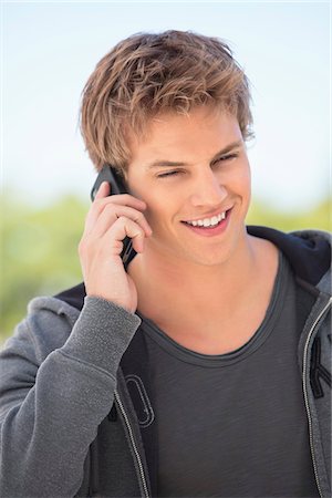 Close-up of a man talking on a mobile phone and smiling Stock Photo - Premium Royalty-Free, Code: 6108-05870067