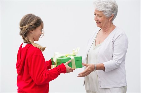 Senior woman giving gift to her granddaughter Stock Photo - Premium Royalty-Free, Code: 6108-05870172