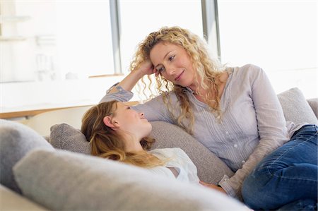 simsearch:6108-05872072,k - Mid adult woman and her daughter looking at each other on a couch Stock Photo - Premium Royalty-Free, Code: 6108-05870396
