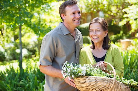 Man with his mother holding basket of flowers outdoors Stock Photo - Premium Royalty-Free, Code: 6108-05870686