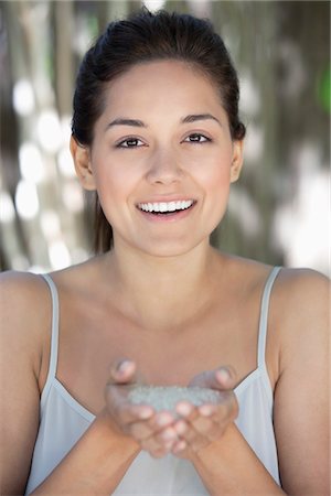 Portrait of a beautiful young woman holding bath salt in hand Stock Photo - Premium Royalty-Free, Code: 6108-05870781