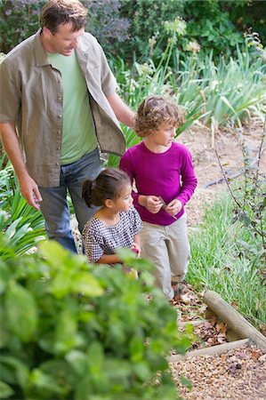 simsearch:6108-06167492,k - Father with two children walking in a garden Stock Photo - Premium Royalty-Free, Code: 6108-05870715