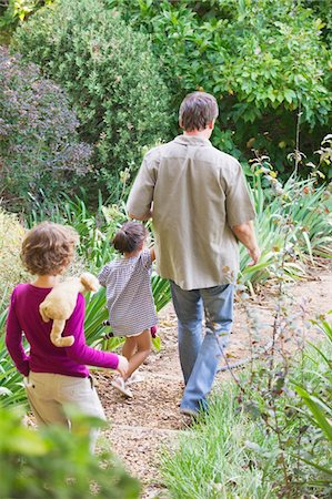 simsearch:6108-06167492,k - Father with two children walking in a garden Stock Photo - Premium Royalty-Free, Code: 6108-05870726