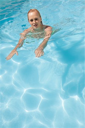 Beautiful woman swimming in a pool Stock Photo - Premium Royalty-Free, Code: 6108-05870929