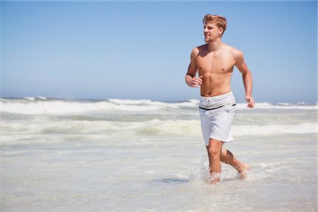simsearch:6108-05872432,k - Man running shirtless on the beach Stock Photo - Premium Royalty-Free, Code: 6108-05871047