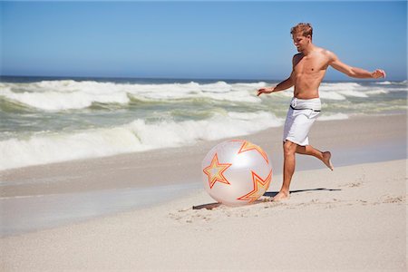 Man kicking ball on the beach Stock Photo - Premium Royalty-Free, Code: 6108-05871012