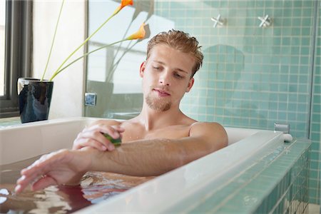 simsearch:6108-05872743,k - Man applying soap on his body Stock Photo - Premium Royalty-Free, Code: 6108-05871014