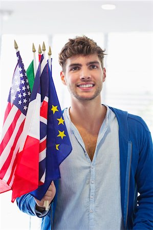 people identity - Portrait of a man holding flags of various countries at an airport Stock Photo - Premium Royalty-Free, Code: 6108-05871268