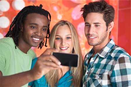 simsearch:6108-06907036,k - Friends taking a picture of themselves with a mobile phone Stock Photo - Premium Royalty-Free, Code: 6108-05871463