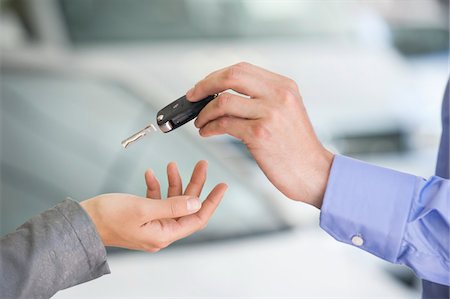 salesman customer car showroom - Salesman handing car key to woman Stock Photo - Premium Royalty-Free, Code: 6108-05871434