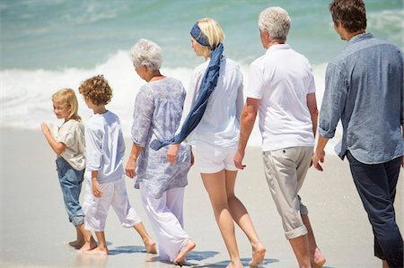 simsearch:6108-05871546,k - Multi génération famille marchant en ligne sur la plage Photographie de stock - Premium Libres de Droits, Code: 6108-05871543