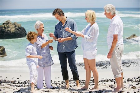 Multi generation family collecting shell on the beach Stock Photo - Premium Royalty-Free, Code: 6108-05871508