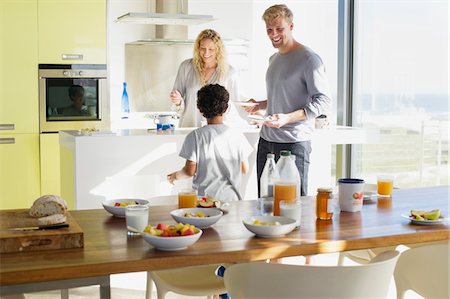 Couple with their son preparing food in a domestic kitchen Stock Photo - Premium Royalty-Free, Code: 6108-05871669
