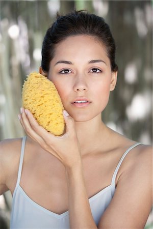 simsearch:6108-05872743,k - Beautiful young woman holding a bath sponge on her face Stock Photo - Premium Royalty-Free, Code: 6108-05871755
