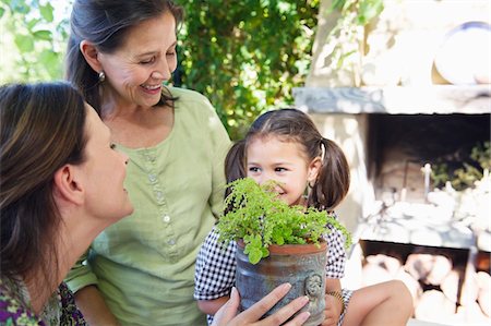 Multi generation family smelling a potted plant Stock Photo - Premium Royalty-Free, Code: 6108-05871796