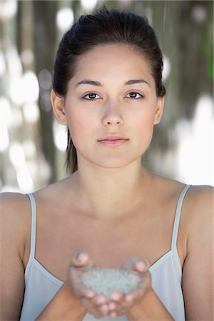 Portrait of a beautiful young woman holding bath salt in hand Stock Photo - Premium Royalty-Free, Code: 6108-05871721