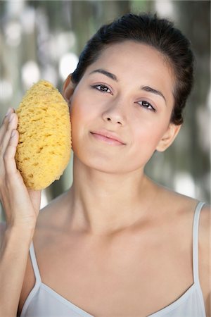 simsearch:6108-05872743,k - Beautiful young woman holding a bath sponge on her face Stock Photo - Premium Royalty-Free, Code: 6108-05871729