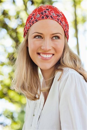 Cheerful young woman wearing bandana and day dreaming Stock Photo - Premium Royalty-Free, Code: 6108-05871860