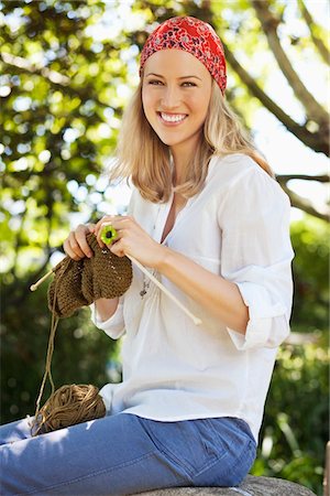 Cheerful young woman knitting Stock Photo - Premium Royalty-Free, Code: 6108-05871874