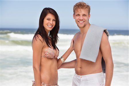 simsearch:6108-05872432,k - Portrait of a cheerful young couple standing on a beach Stock Photo - Premium Royalty-Free, Code: 6108-05871990