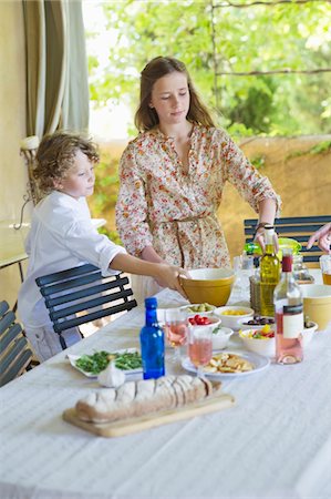 simsearch:6108-07969525,k - Siblings arranging food at dining table Stock Photo - Premium Royalty-Free, Code: 6108-05871915