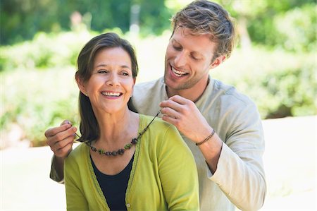 Man fastening mom's necklace outdoors Stock Photo - Premium Royalty-Free, Code: 6108-05871927