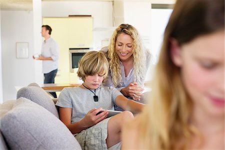 simsearch:6108-06904945,k - Teenage boy using a digital tablet with his mother looking at him and smiling Stock Photo - Premium Royalty-Free, Code: 6108-05872041