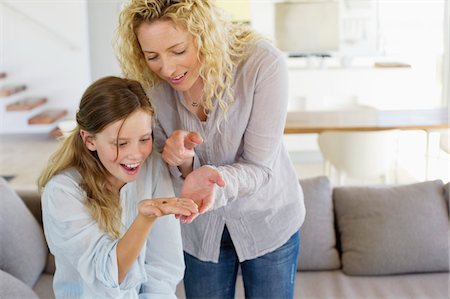 simsearch:6108-05872072,k - Mid adult woman looking at her daughter's palm and smiling Stock Photo - Premium Royalty-Free, Code: 6108-05872077