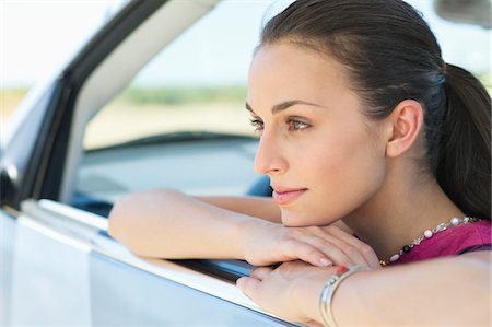 Young woman looking out of car window Stock Photo - Premium Royalty-Free, Code: 6108-05872187