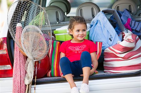 Cute little girl sitting in car trunk Stock Photo - Premium Royalty-Free, Code: 6108-05872191