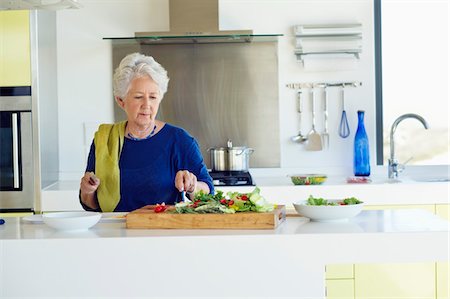 simsearch:6108-06167085,k - Senior woman cutting vegetable in a kitchen Stock Photo - Premium Royalty-Free, Code: 6108-05872379
