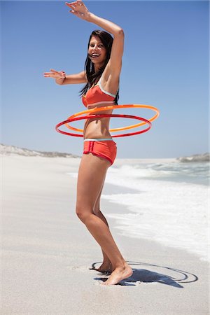 simsearch:6108-05872432,k - Woman playing with plastic hoops on the beach Stock Photo - Premium Royalty-Free, Code: 6108-05872474