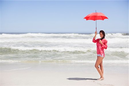 simsearch:6108-05872432,k - Woman standing on the beach with an umbrella Stock Photo - Premium Royalty-Free, Code: 6108-05872438
