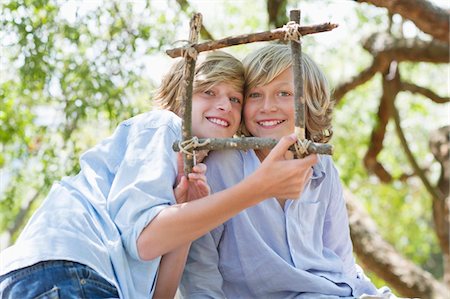 simsearch:649-05649029,k - Portrait of children looking through frame of driftwood outdoors Stock Photo - Premium Royalty-Free, Code: 6108-05872679