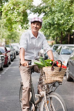 person in a basket of a bike - Man carrying vegetables on a bicycle, Paris, Ile-de-France, France Stock Photo - Premium Royalty-Free, Code: 6108-05872808