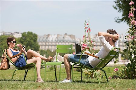 simsearch:6108-05873097,k - Man using a laptop with a woman talking on a mobile phone, Jardin des Tuileries, Paris, Ile-de-France, France Stock Photo - Premium Royalty-Free, Code: 6108-05872999