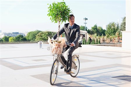 Businessman carrying a plant on a bicycle, Eiffel Tower, Paris, Ile-de-France, France Stock Photo - Premium Royalty-Free, Code: 6108-05872900