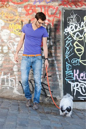 puppy leash images - Man with a puppy in front of a graffiti wall, Paris, Ile-de-France, France Stock Photo - Premium Royalty-Free, Code: 6108-05873041