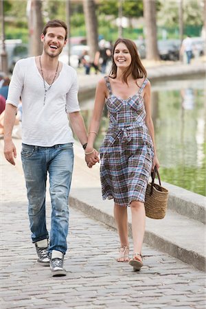 Couple walking near a canal and smiling, Paris, Ile-de-France, France Stock Photo - Premium Royalty-Free, Code: 6108-05873081