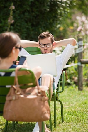 simsearch:6108-05873097,k - Man sitting in a garden and looking at a laptop, Paris, Ile-de-France, France Stock Photo - Premium Royalty-Free, Code: 6108-05873098