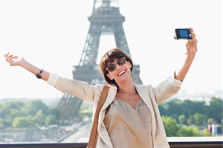 paris one woman - Femme de prendre une photo d'elle-même avec la tour Eiffel en arrière-plan, Paris, Ile-de-France, France Photographie de stock - Premium Libres de Droits, Code: 6108-05873314