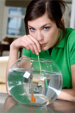 Young woman drinking aquarium water with a straw Stock Photo - Premium Royalty-Free, Code: 6108-05873446