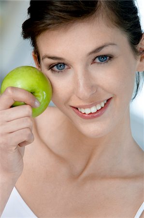 Portrait of a young woman eating an apple Stock Photo - Premium Royalty-Free, Code: 6108-05873469
