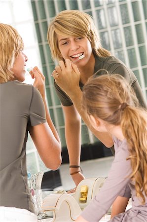 simsearch:6108-05860263,k - Teenage boy brushing his teeth with his sister looking at him Stock Photo - Premium Royalty-Free, Code: 6108-05873707