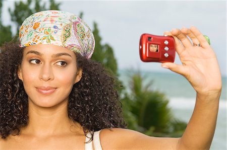 Woman taking a picture of herself with a digital camera Stock Photo - Premium Royalty-Free, Code: 6108-05873739