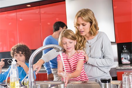 simsearch:6108-05860153,k - Woman washing hands of her daughter in the kitchen Stock Photo - Premium Royalty-Free, Code: 6108-05873987