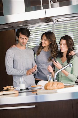 simsearch:6108-05861651,k - Three friends having breakfast in the kitchen Stock Photo - Premium Royalty-Free, Code: 6108-05873924