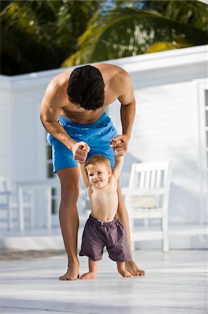 Man helping his son to walk Stock Photo - Premium Royalty-Free, Code: 6108-05874042